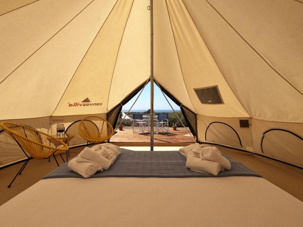 a tent with two beds in it with a view of the ocean at Quinta da Boa Sorte in Estói