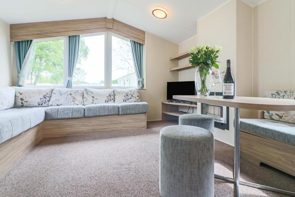 uma sala de estar com um sofá e uma mesa em Beachside caravan em Mablethorpe