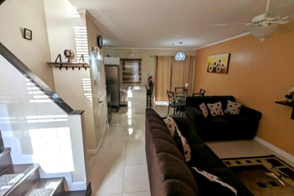 uma sala de estar com um sofá e uma cozinha em Comfy Seascape Retreat near Kingston Airport em Kingston