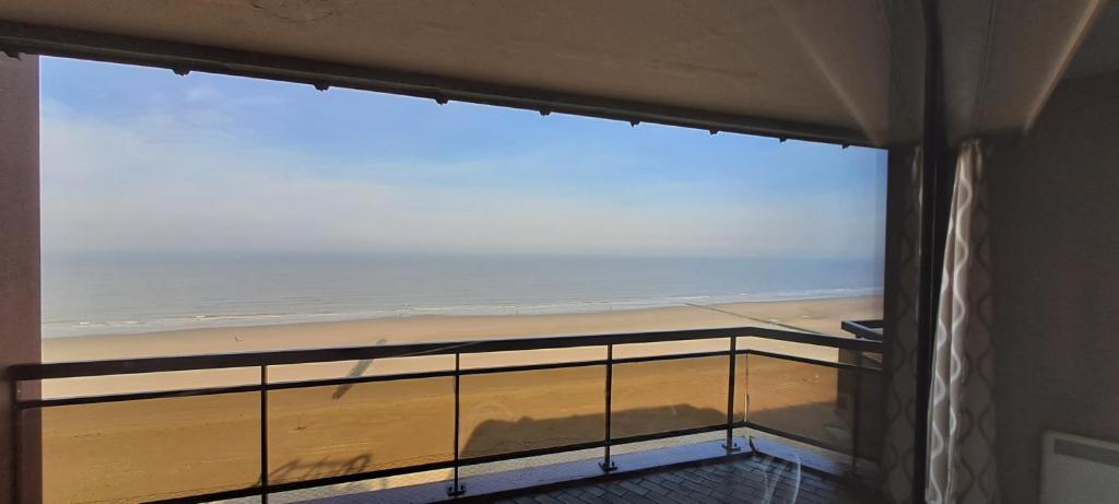 ブランケンベルヘにあるLarge beachstudio seaview Blankenberge near Bruggeのビーチの景色を望むバルコニーが備わる客室です。