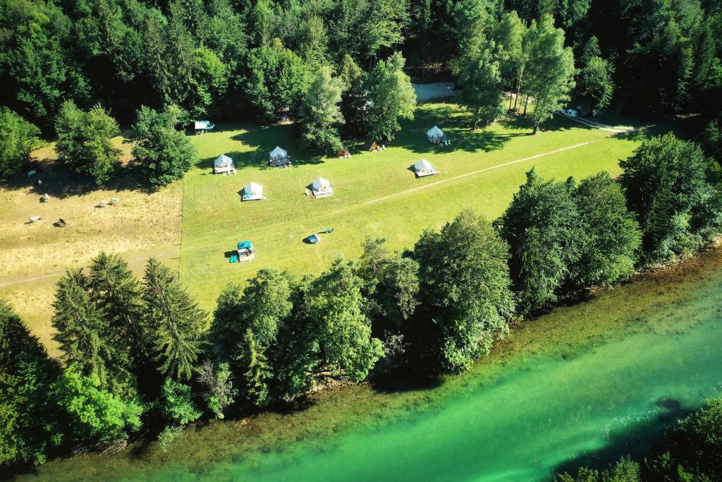 an overhead view of a field with tents and a lake at ECO River Camp in Radovljica