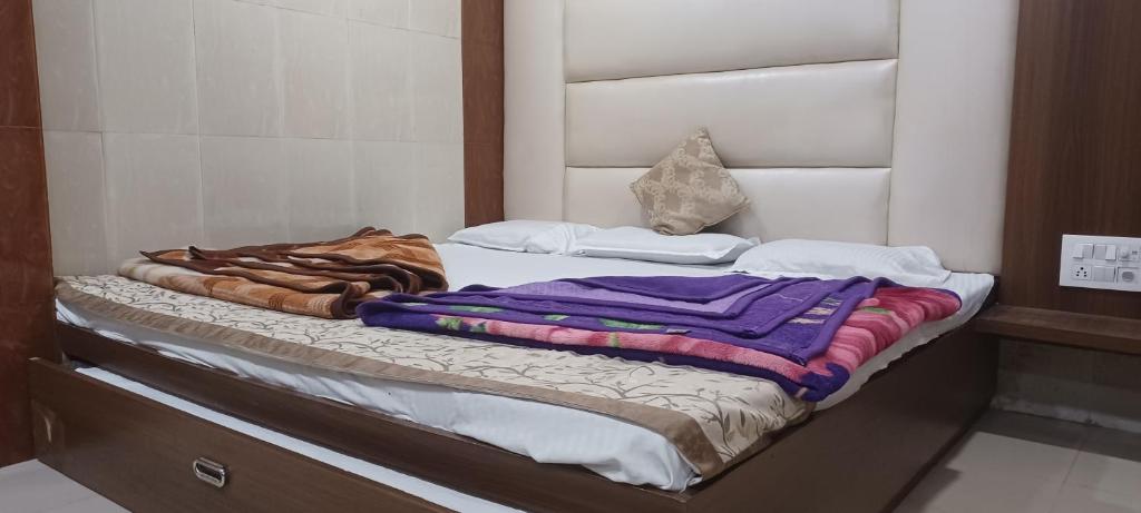 a bed with a bunch of blankets on it at Hotel Ajmer in Ajmer