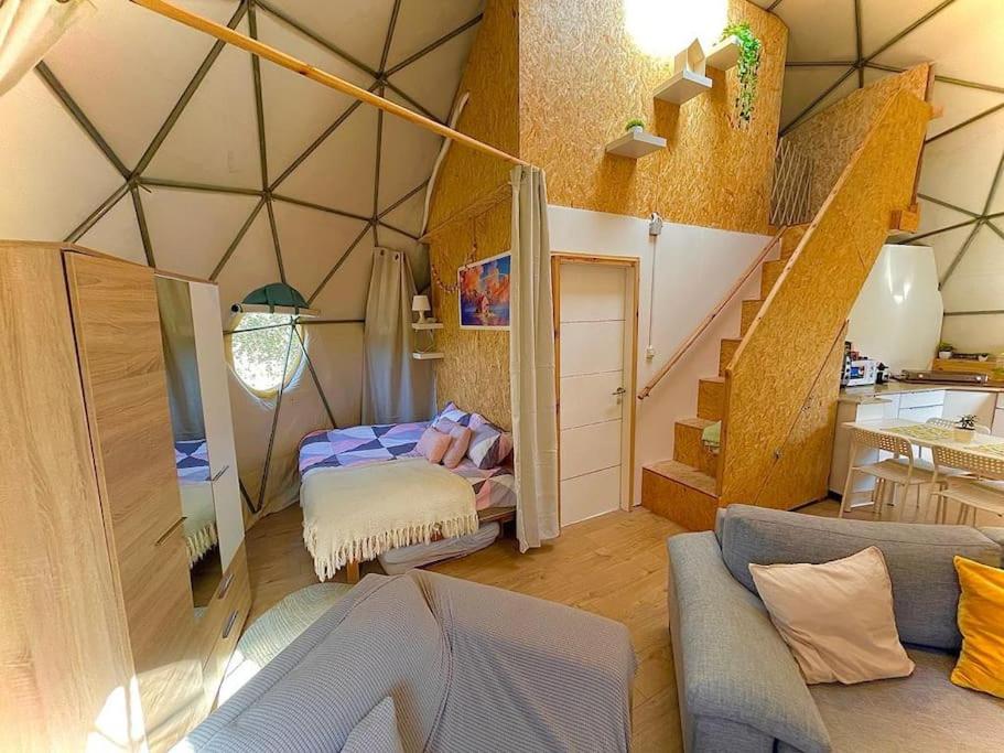 Una habitación con cama y escaleras en una tienda en Dome in the Olive Grove כיפה גיאודזית ענקית ומודרנית בין עצי הזית en Yavneʼel