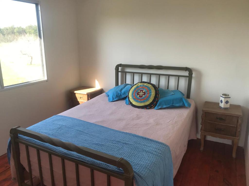 Un dormitorio con una cama con almohadas azules. en Chacra marítima en Garzon Jose ignacio, en José Ignacio