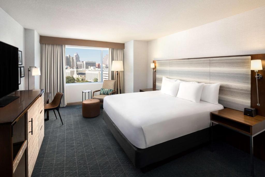 una habitación de hotel con una gran cama blanca y una ventana en Grand Hyatt San Antonio River Walk, en San Antonio