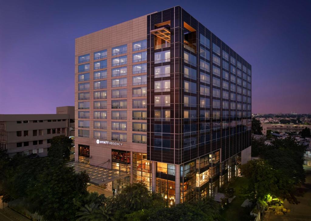 un edificio alto con luces encendidas delante de él en Hyatt Regency Ahmedabad, en Ahmedabad