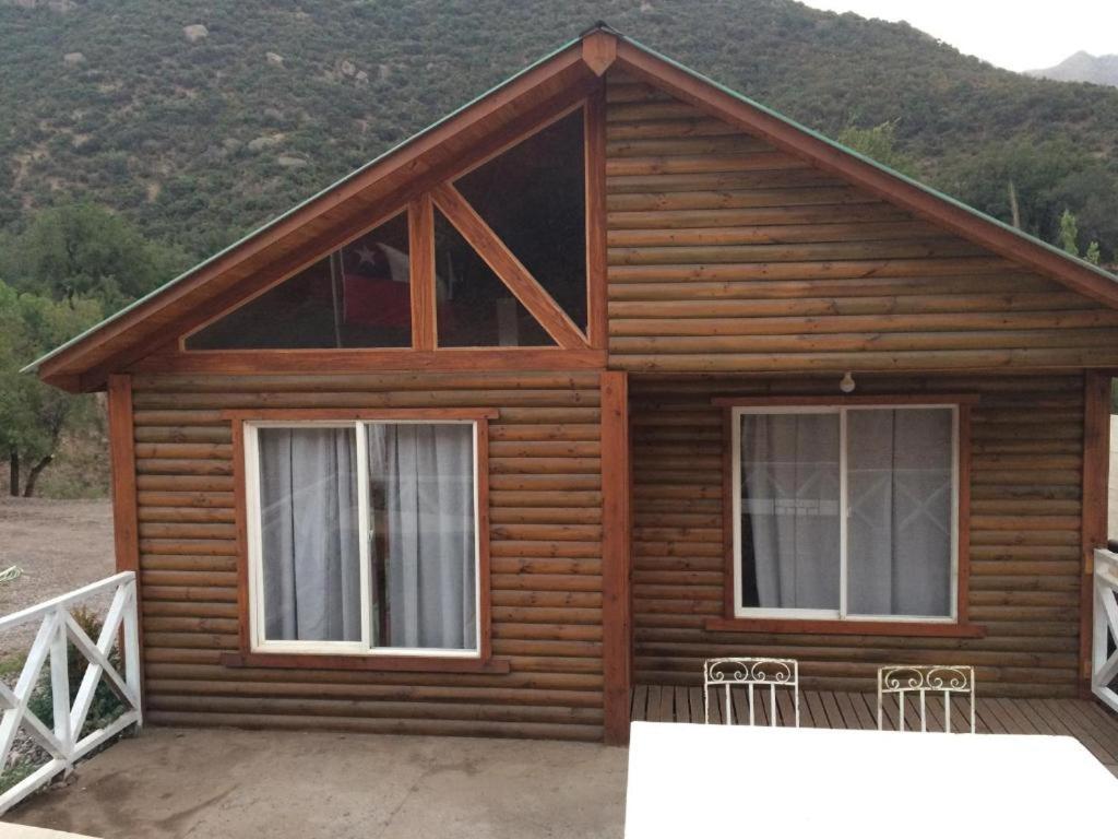 a log cabin with two windows and a porch at Cabañas con bajada al río in Guayacán