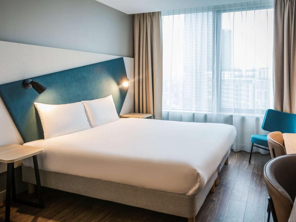 a hotel room with a large bed and a window at Aparthotel Adagio London Stratford in London