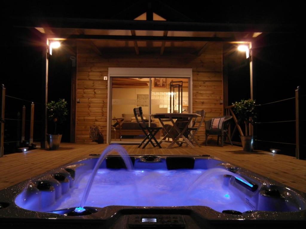 una bañera de hidromasaje en medio de un patio por la noche en MAROSENIA TTIKI - Cabanes et Spa, en Ascain