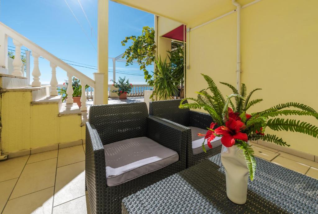 a balcony with a chair and a plant in a vase at Amazing view apartment Slavica 3 in Dubrovnik