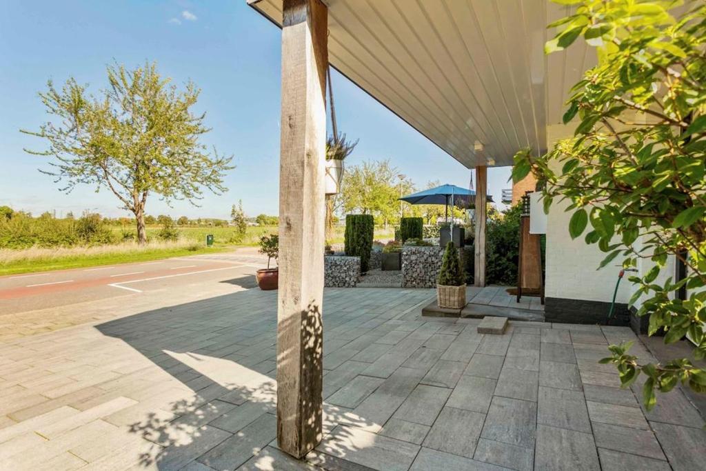 a building with a wooden pole next to a street at Vakantie studio Eijsden in Eijsden