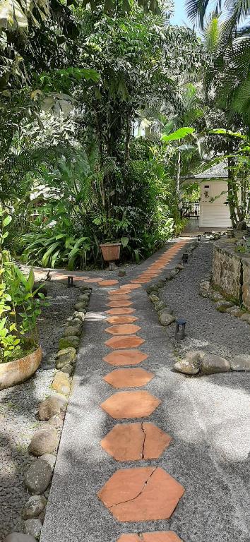 a walkway with red stones in a garden at Les Gîtes de la Lézarde in Petit-Bourg