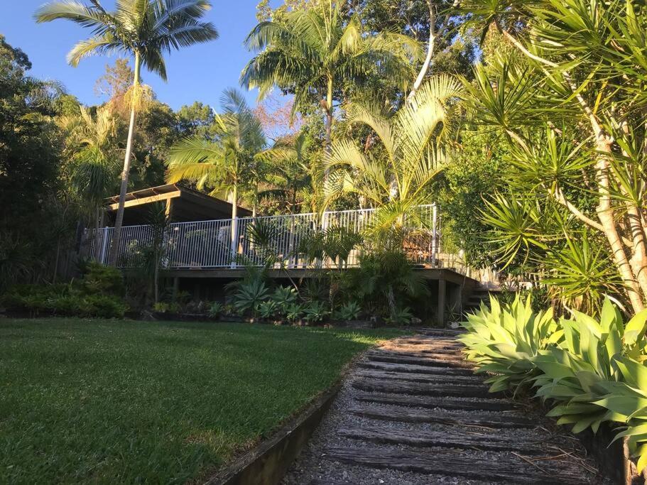 a walkway in front of a house with palm trees at LA Inspired, Gorgeous Spacious Family Home, Superb Location in Noosa Heads