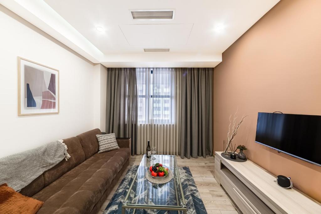 ein Wohnzimmer mit einem Sofa und einem Flachbild-TV in der Unterkunft Volga Apartment by Downtown Inn in Yerevan