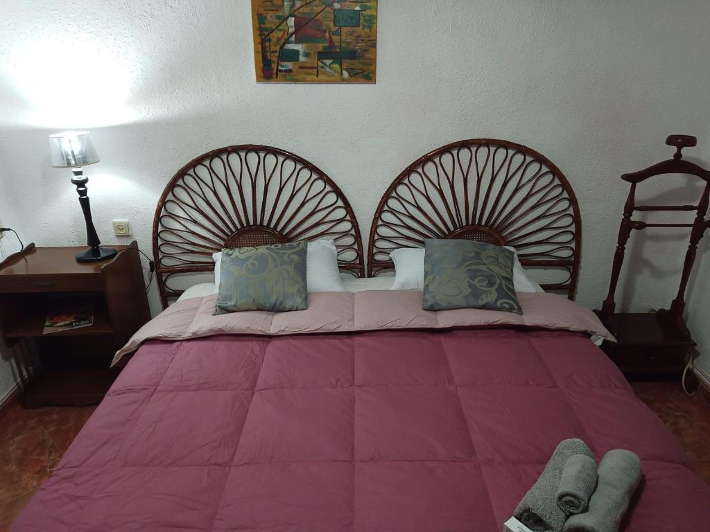 1 dormitorio con 1 cama rosa grande y 2 cabezales de madera en Tourist room, en Valencia