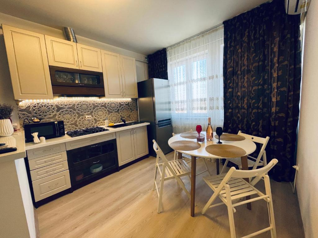 una cucina con tavolo e sedie in una stanza di Apartament ELLA a Tulcea