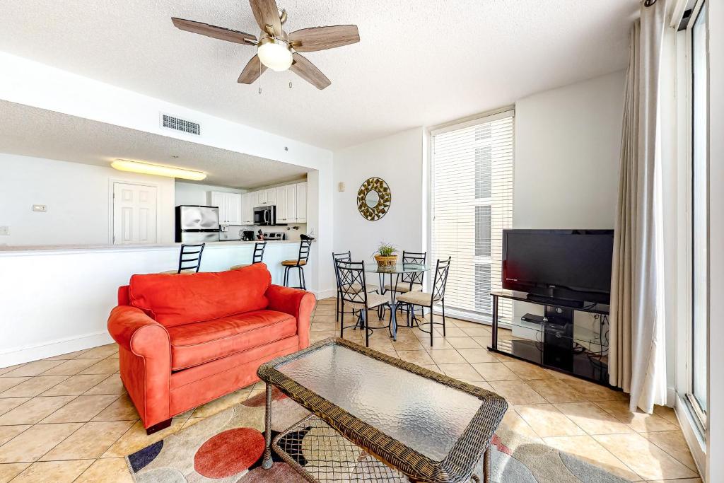 ein Wohnzimmer mit einem roten Sofa und einem TV in der Unterkunft Majestic Beach Resort Tower 1 #915 in Panama City Beach