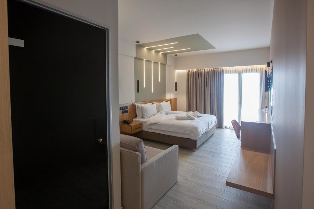 a hotel room with a bed and a living room at AKROTHEA suites & lounge in Tripoli