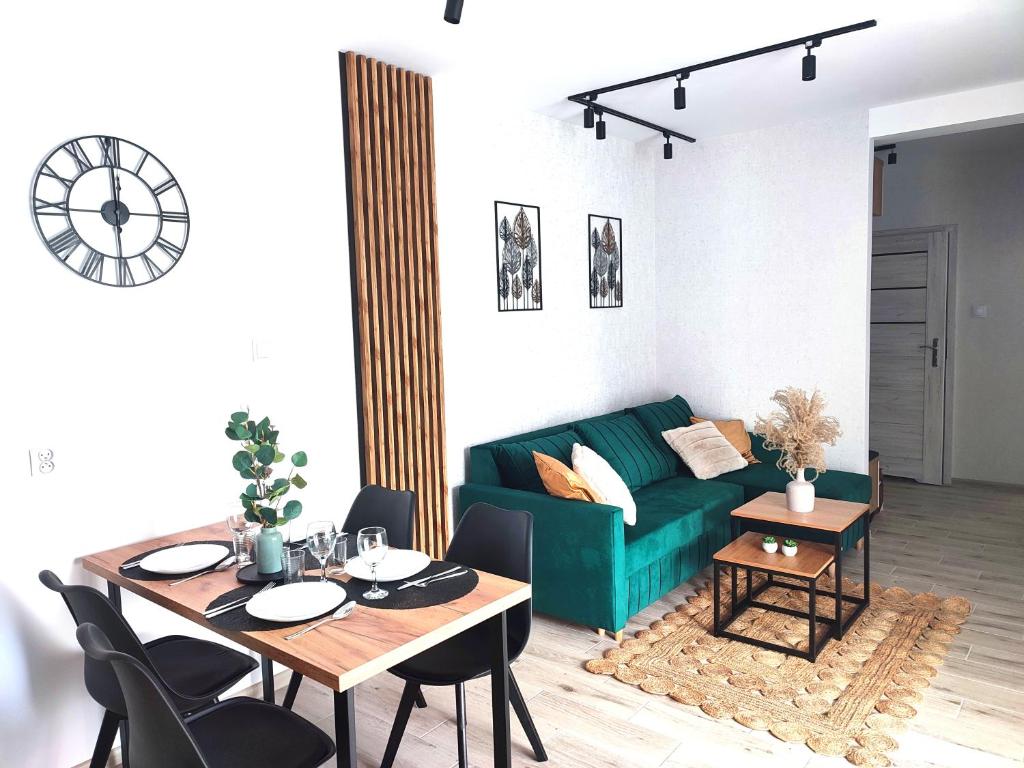 a living room with a green couch and a table at Apartament DanHouse in Giżycko