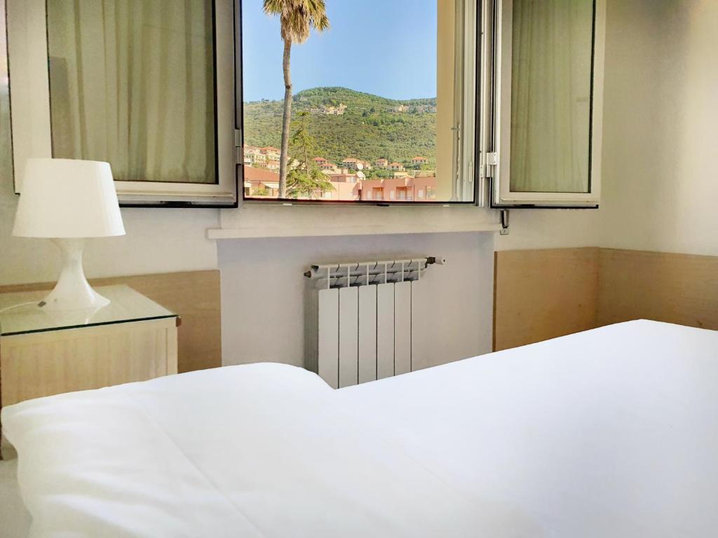a bedroom with a bed and a window with a view at Ligure Residence in Borgio Verezzi