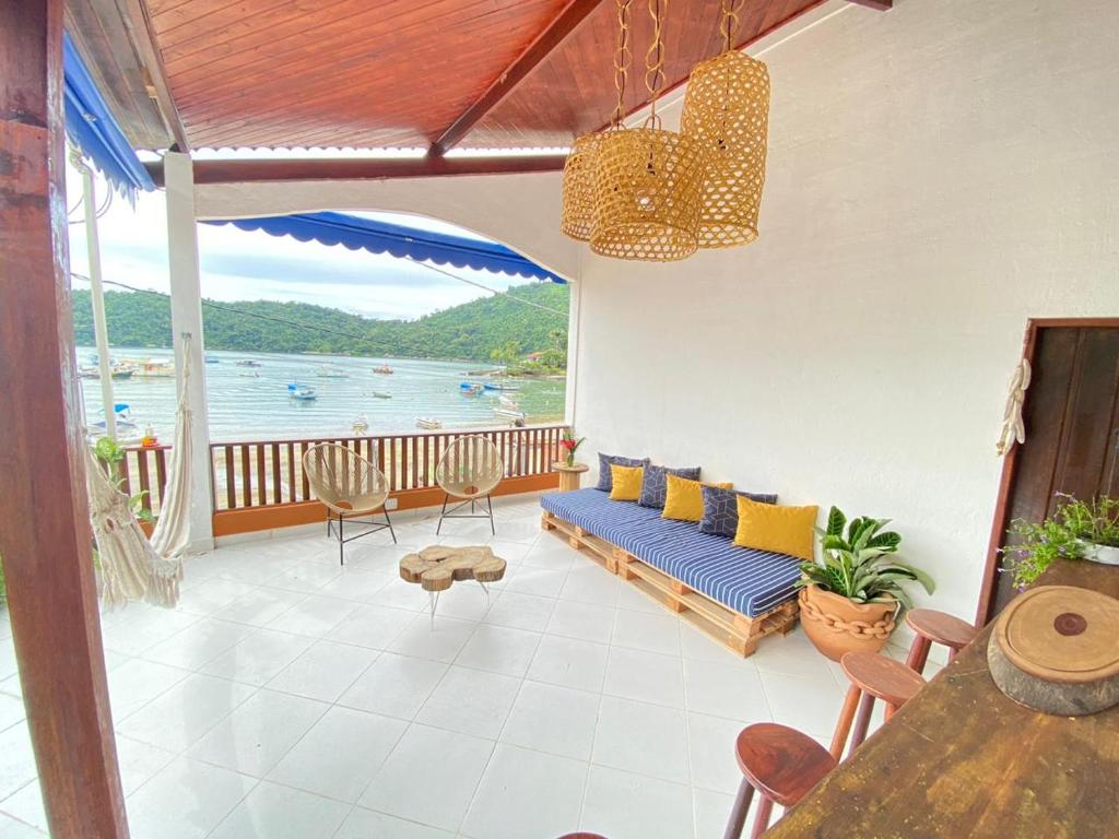 a living room with a couch and a view of the water at Samburá Paraty in Paraty