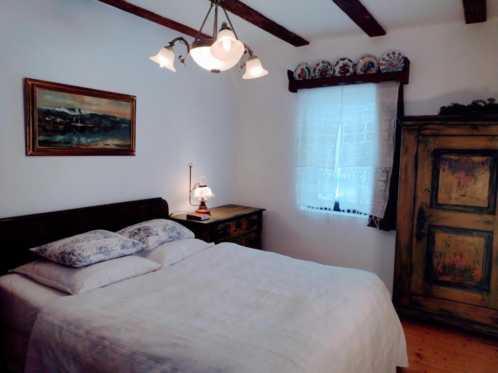 um quarto com uma cama branca e uma janela em Apartvilla Serbota em Porumbacu de Sus