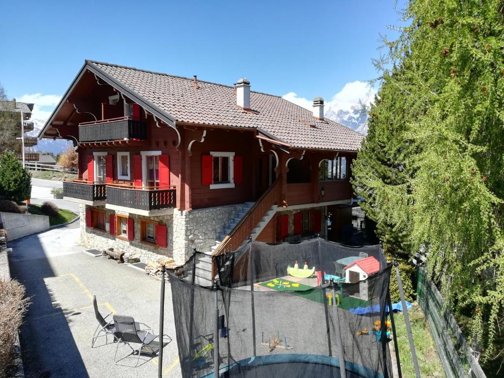 a house with a fence in front of it at Chant du Torrent: 12 pers. idéal pour les familles in Nendaz