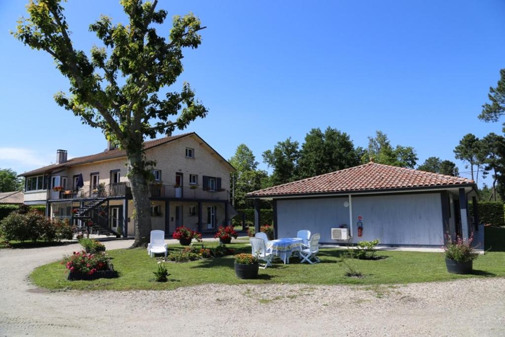 a house with a table and chairs in the yard at La Farguaise in Fargues-de-Langon