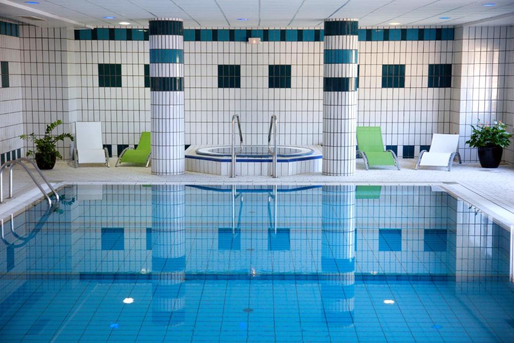 a swimming pool with a tub in the middle at Hôtel Spa Du Béryl in Bagnoles de l'Orne