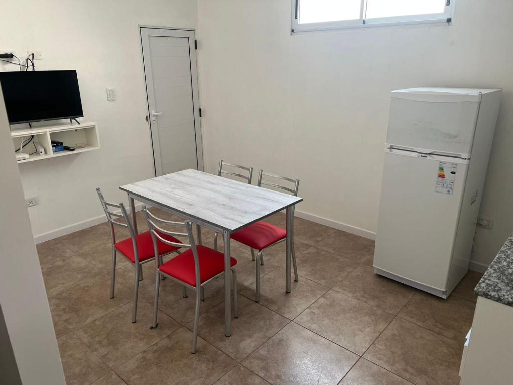 a kitchen with a table and chairs and a refrigerator at Departamento guemes D in San Pedro