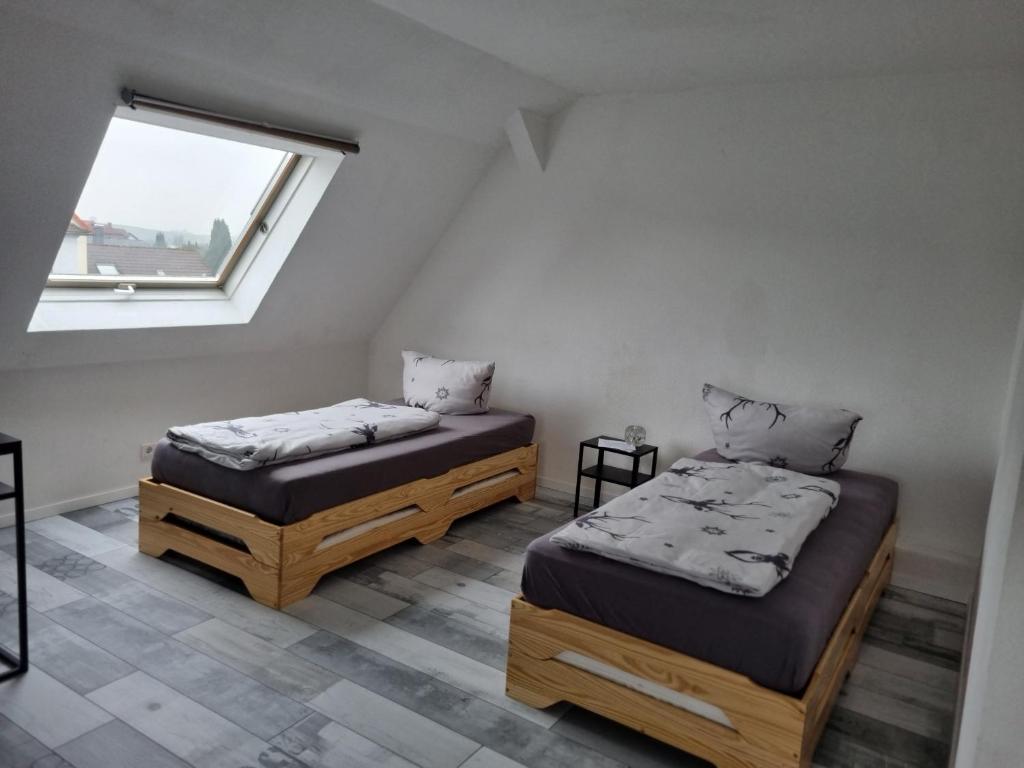 two twin beds in a room with a window at Ferienwohnung in Barntrup