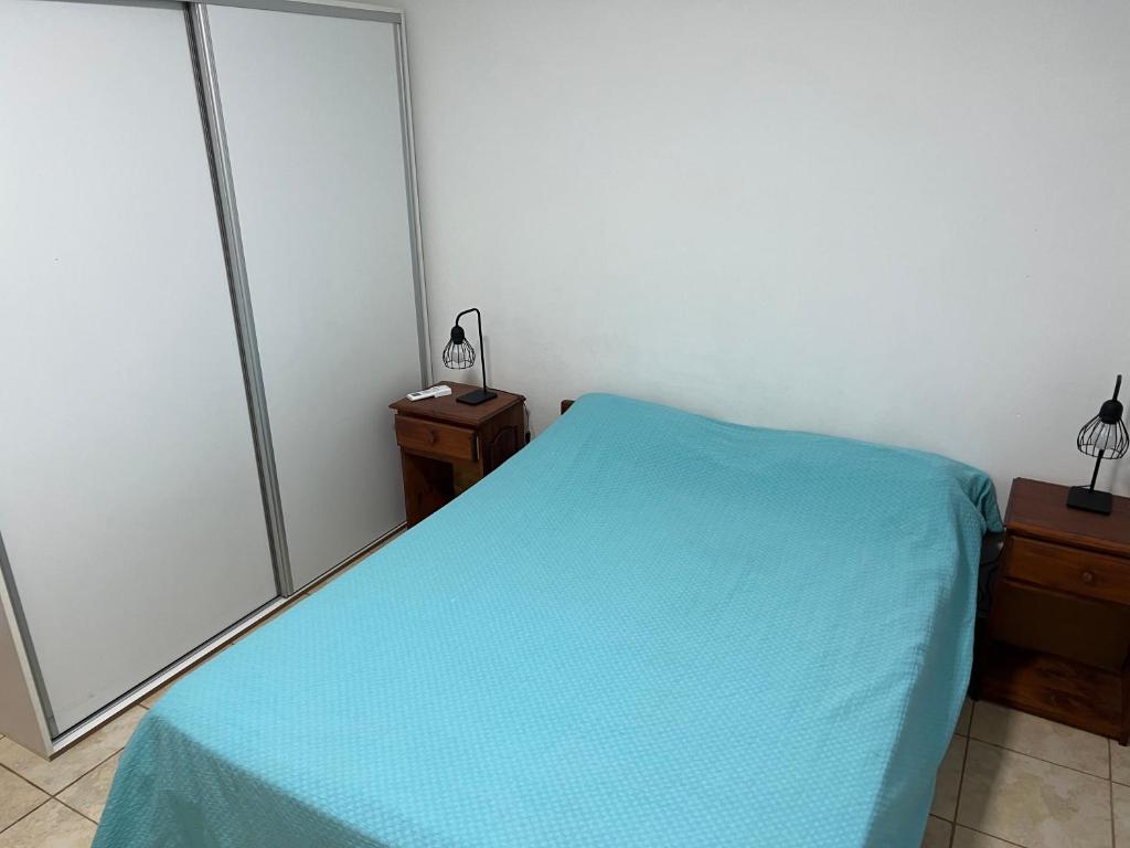 Un dormitorio con una cama con una sábana azul. en DPTOS 3 DE FEBRERO en San Pedro