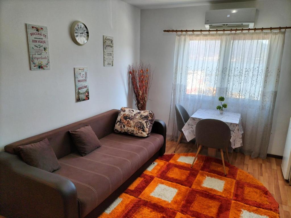 a living room with a brown couch and a table at Apartament Home Comfort in Orşova