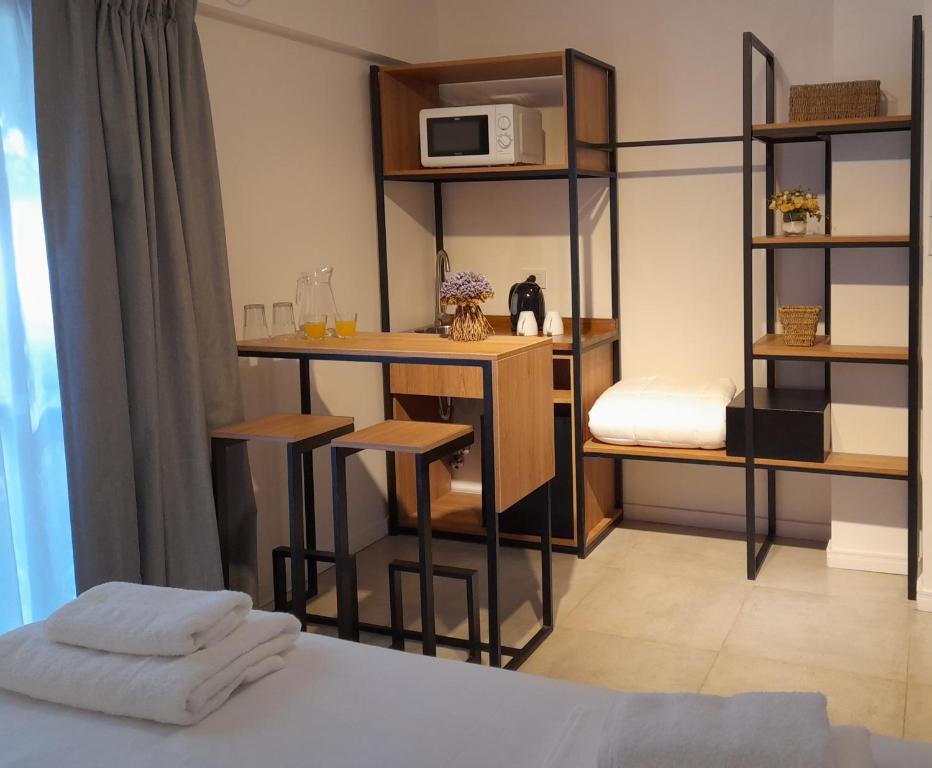 a room with a bed and a desk with a microwave at Casa Be Suites in Rosario