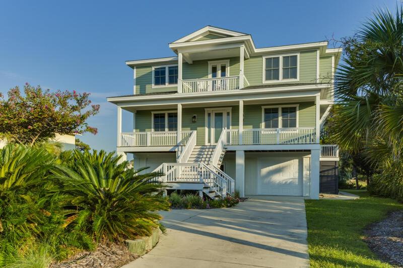 a large green house with stairs and palm trees at 449 Tarpon Blvd in Fripp Island