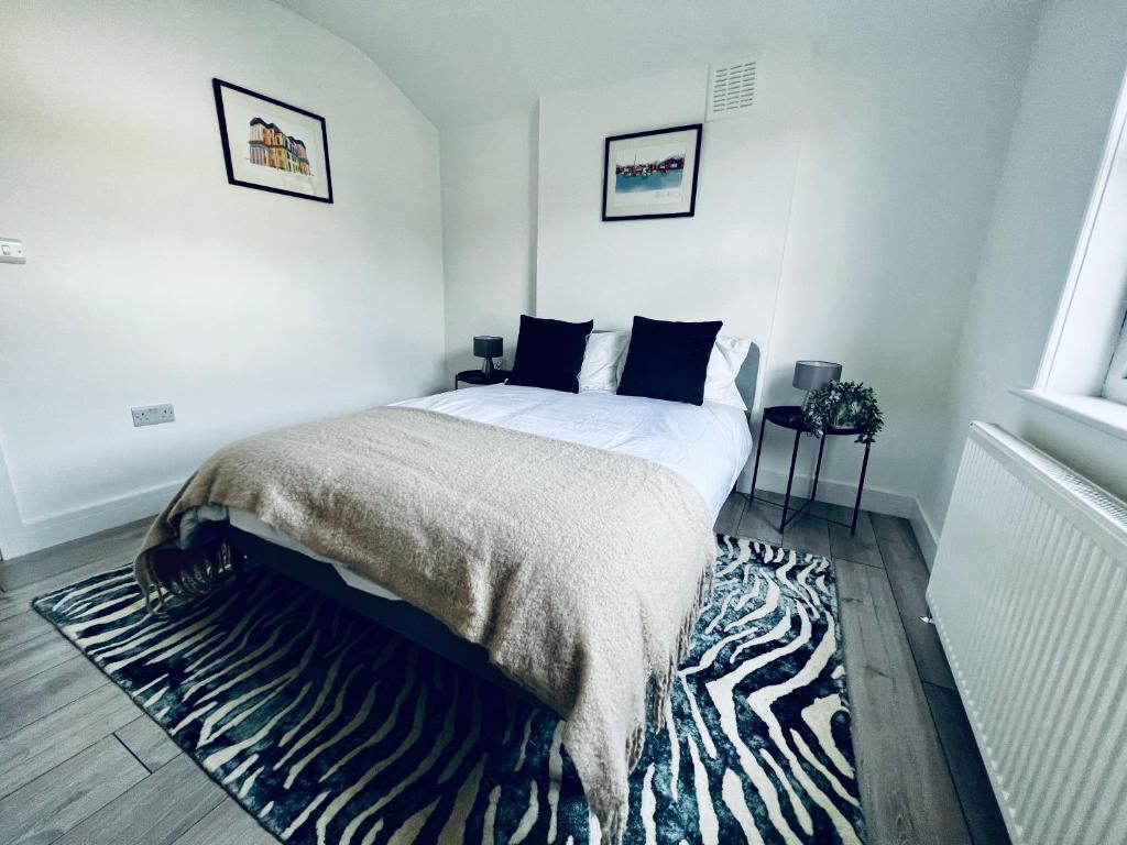 a bedroom with a bed with a zebra rug at Neils Place hosted by AirOperate in London