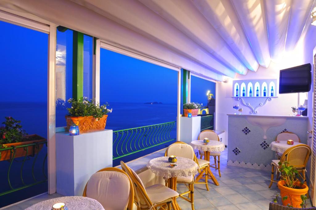 a restaurant with tables and chairs and a view of the ocean at Palazzo Talamo in Positano
