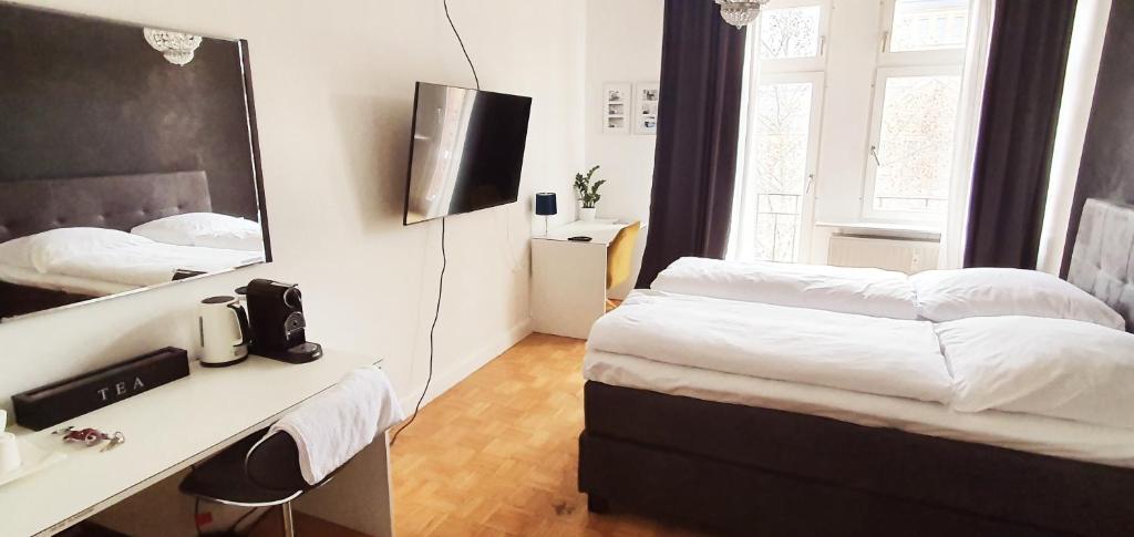 Schlafzimmer mit einem Bett und einem Schreibtisch mit einem Spiegel in der Unterkunft sonniges Zimmer mit Balkon im Herzen Mannheims in Mannheim