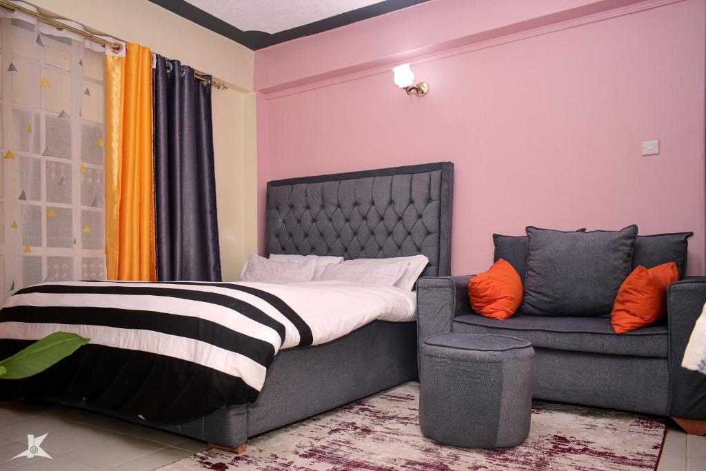 um quarto com uma cama e um sofá em Pazuri studios kisii em Kisii