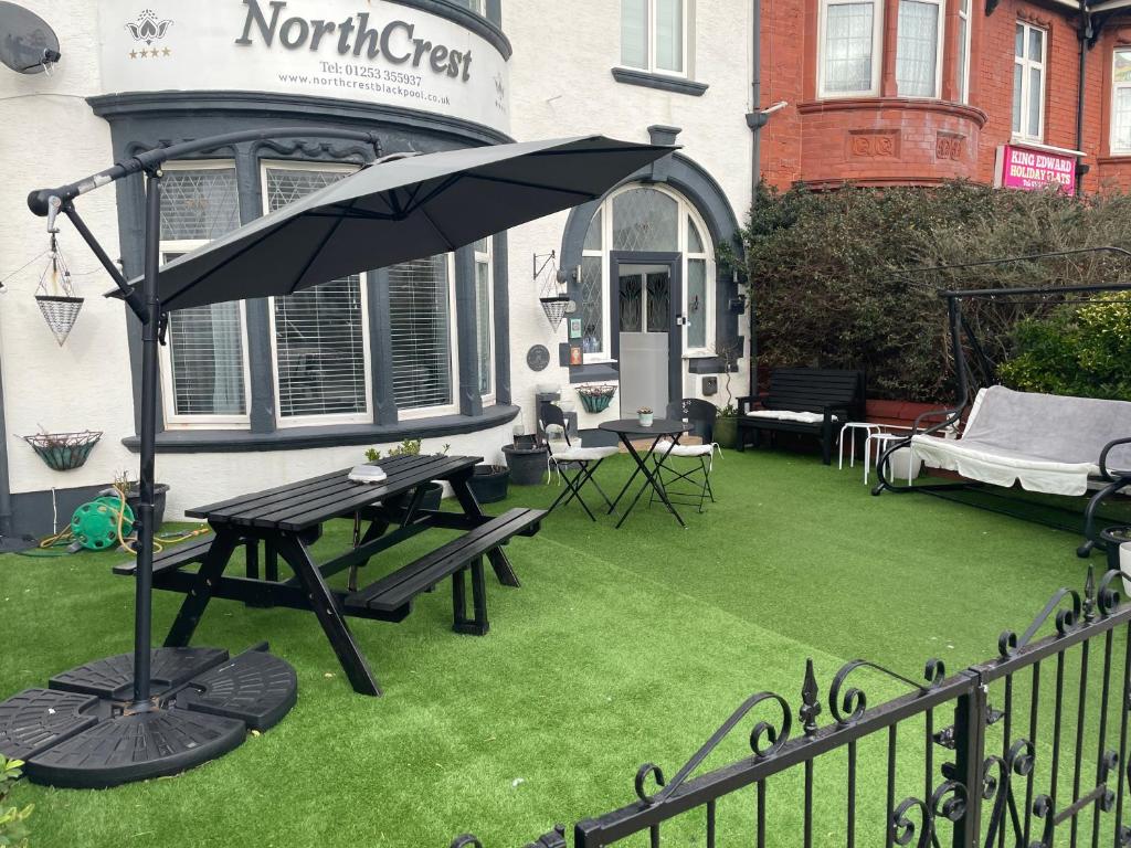 a patio with a picnic table and an umbrella at North Crest in Blackpool