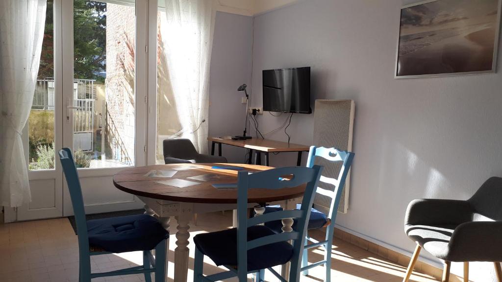 - une salle à manger avec une table et des chaises en bois dans l'établissement LA PLAGE, à Berck-sur-Mer