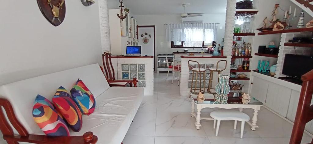 a living room with a white couch and a table at CONDOMÍNIO ILHAS DO JUQUEHY in Sao Paulo