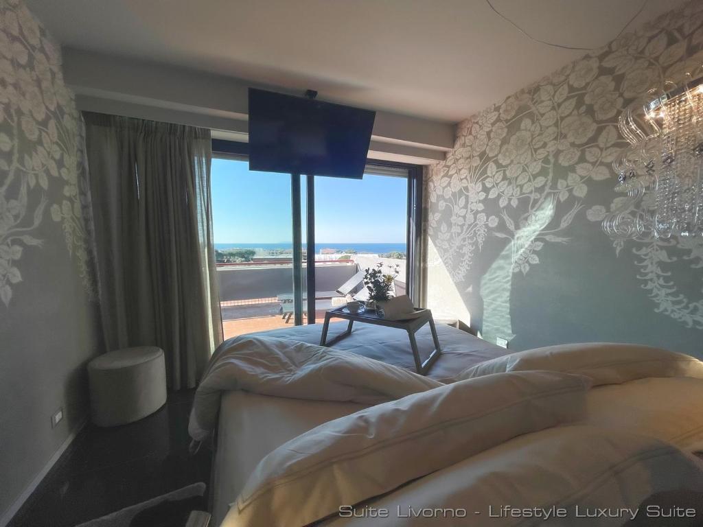 a bedroom with two beds and a large window at Lifestyle Luxury Suite - Your Frame Over the Sea - Suite Livorno Holiday Home in Livorno