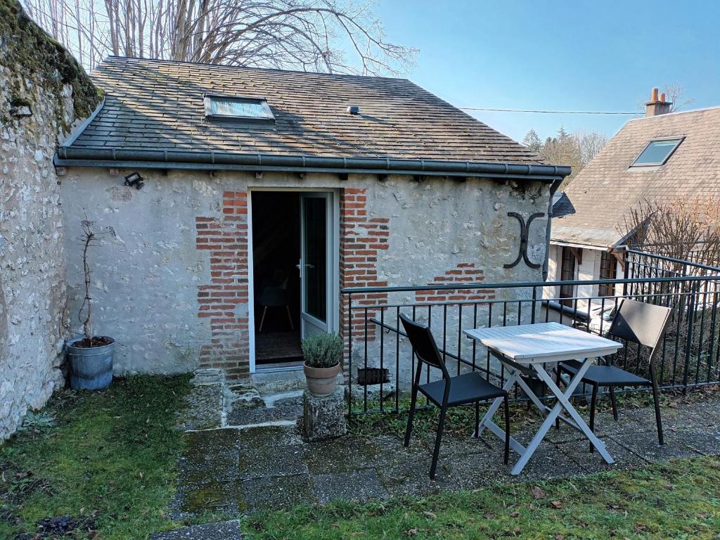 een tafel en stoelen voor een gebouw bij Mini Gite Les Marais Beaugency in Beaugency