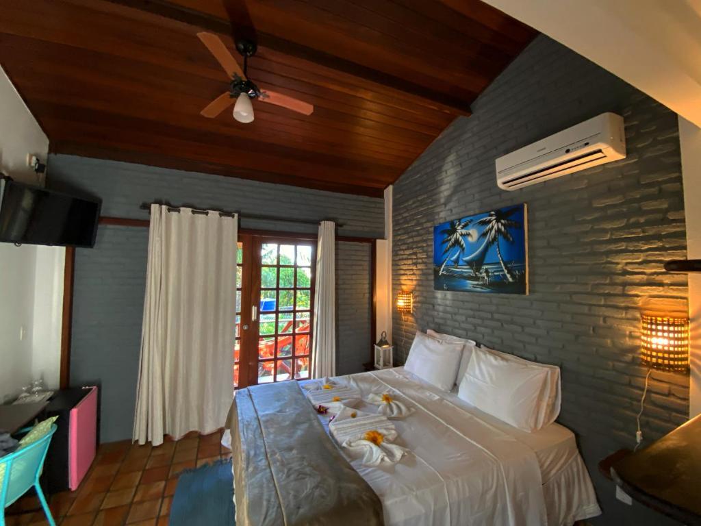 a bedroom with a large white bed in a room at Pousada Pomar da Pipa in Pipa