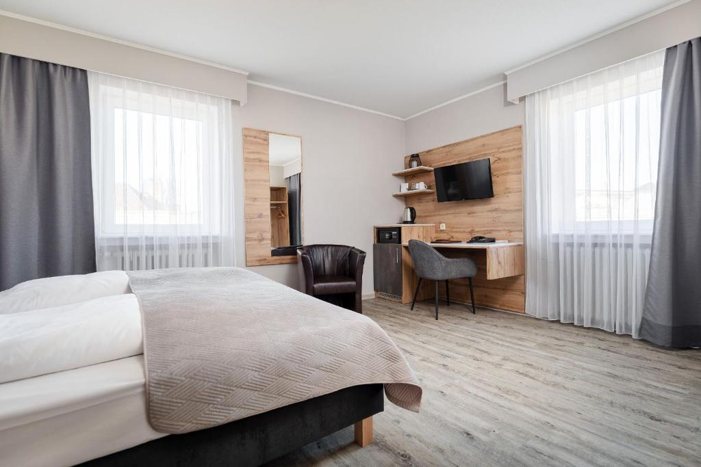 Cette chambre comprend un lit et un bureau. dans l'établissement Hotel am Ludwigsplatz, à Giessen