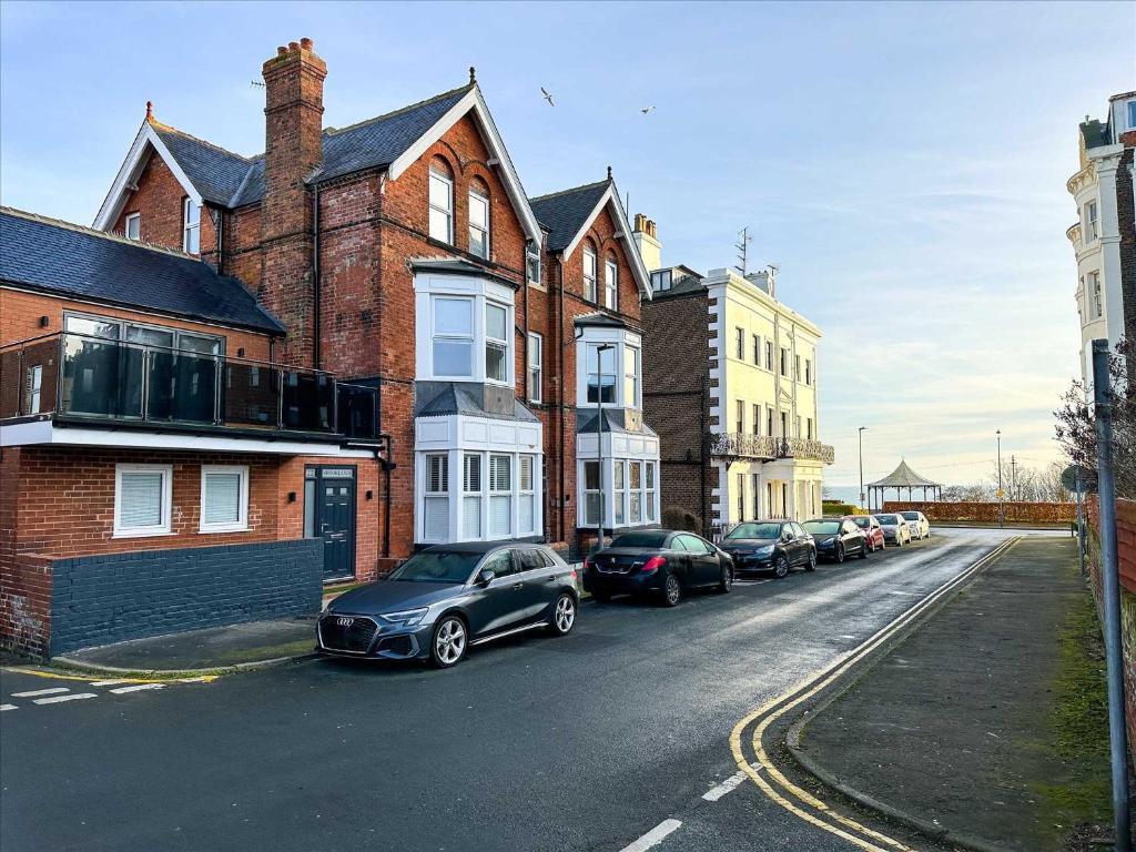 a row of cars parked on the side of a street at Brooklands Filey Seaside Retreat Flat 6 in Filey