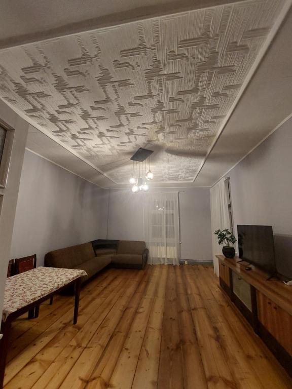 una sala de estar vacía con sofá y TV en Pils ielas apartamenti, en Kandava