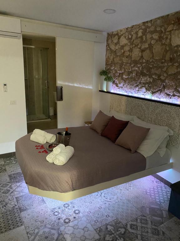 a bedroom with a large bed with towels on it at Brimiky House in Siracusa