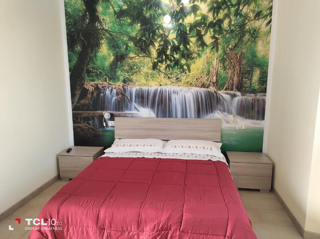 una camera con letto rosso e murale a cascata di Villa ARA rossa a Canegrate